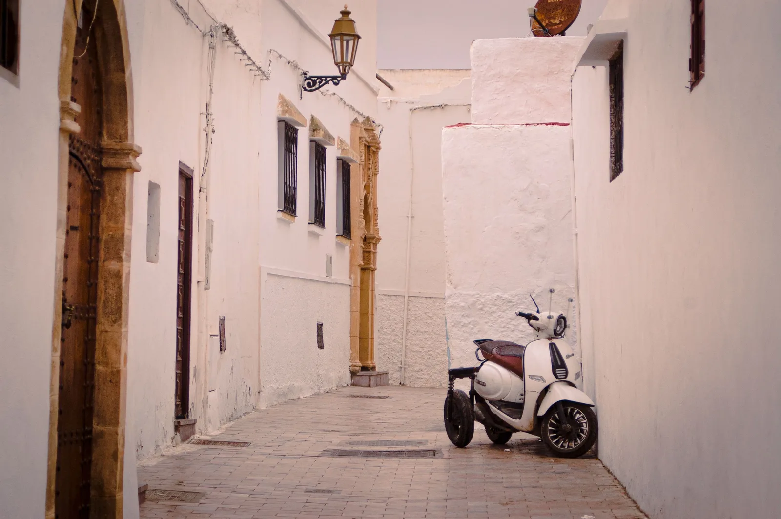 A scooter in a whitewashed alley